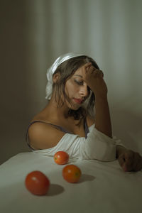 Portrait of young woman sitting on bed at home