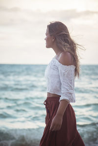 Young woman standing at beach