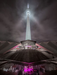 Low angle view of illuminated tower against cloudy sky