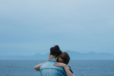 Rear view of couple on sea against sky