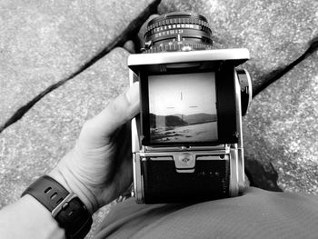 Midsection of person photographing at camera