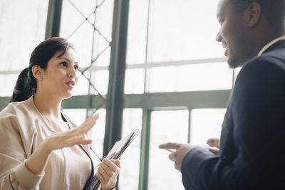 Businesswoman sharing ideas with male coworker in meeting at office