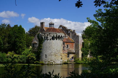 View of building by lake against sky