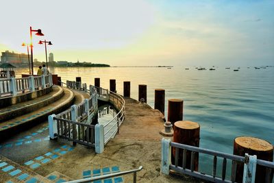 Pier over sea against sky during sunset