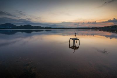 Scenic view of lake against sky at sunset
