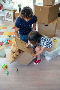 High angle view of mother and girl with toy on floor