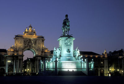 Statue at praca do comercio against sky in city during dusk