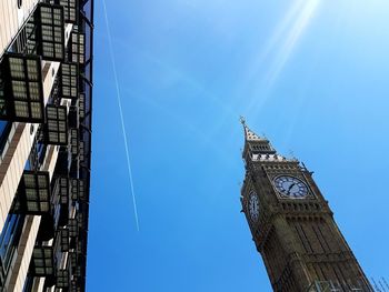 Low angle view of clock tower against blue sky