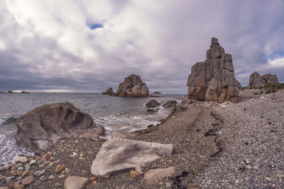 Rocks on beach against sky