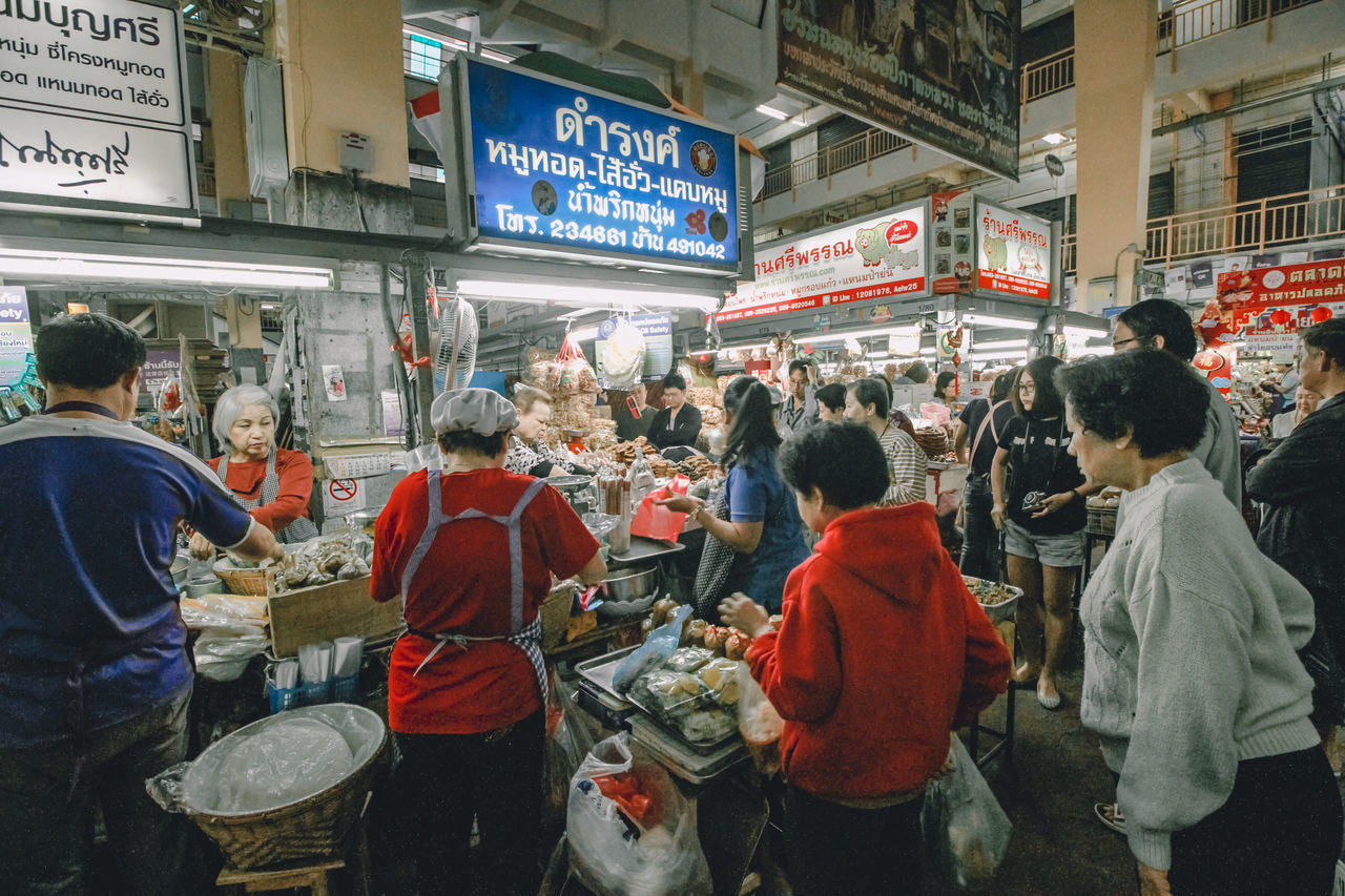 GROUP OF PEOPLE IN FRONT OF BUILDINGS