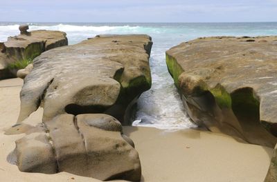 Close-up of rocks on beach against sky