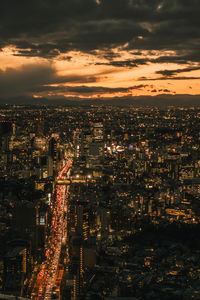 High angle view of illuminated cityscape against sky at night