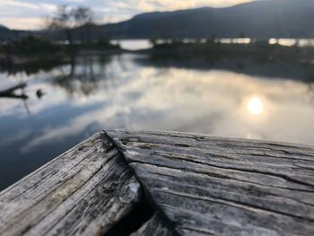 Close-up of wooden pier over lake against sky