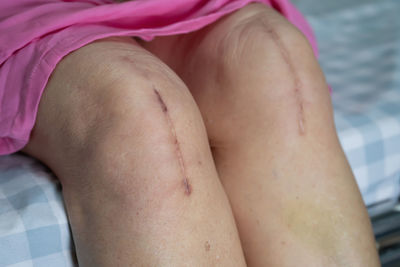 Midsection of woman relaxing on bed