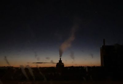 Silhouette buildings against sky at night