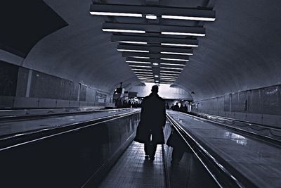 Rear view of man walking on railroad station