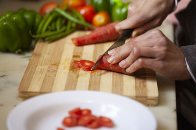 Cropped image of person preparing food on cutting board