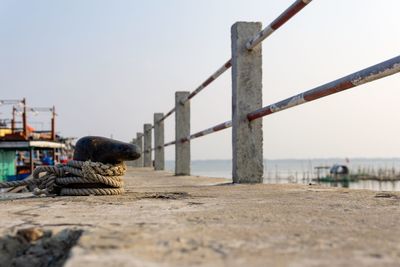 Surface level of pier on beach against clear sky