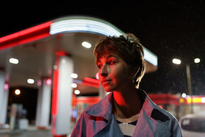 Portrait of young woman looking away at night