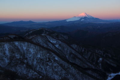 Scenic view of snowcapped mountains against sky during sunset