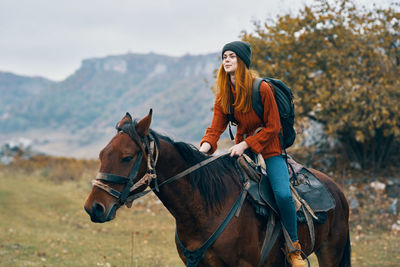 Young woman riding horse