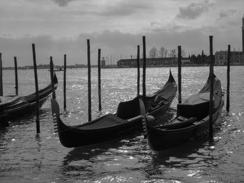 Boats moored in sea with city in background