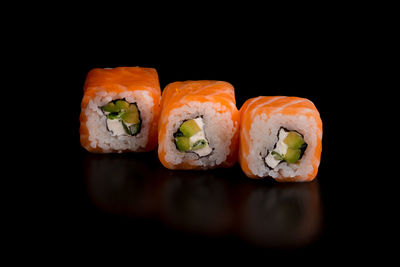 Close-up of sushi against black background