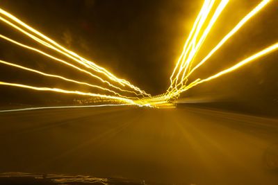 View of glowing light trails seen from car windshield at night