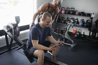 Man and woman looking at digital tablet in gym