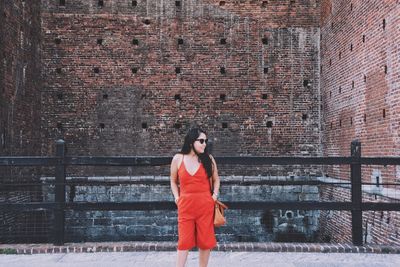 Woman standing against brick wall