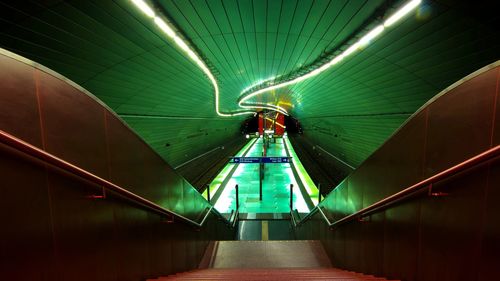 Low angle view of illuminated escalator in subway