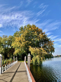 Footpath by lake against sky