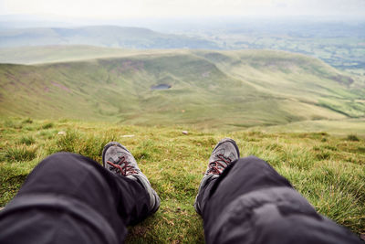 Low section of man relaxing on mountain