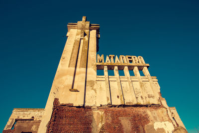 Low angle view of matadero madrid against clear blue sky in city