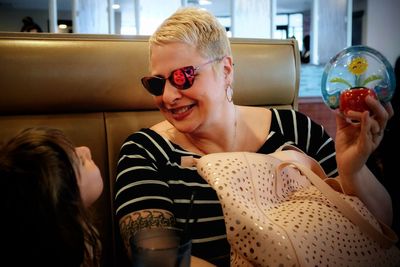 Cheerful girl with grandmother sitting at cafe