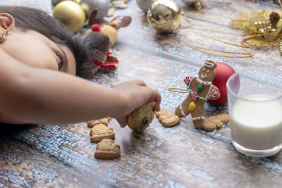 Close-up of girl playing with toy while lying down on wooden flooring