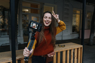 Content creator, blogger, vlogger young woman taking selfies, filming herself and having fun 