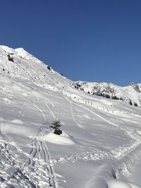 Scenic view of snowcapped mountains against clear blue sky