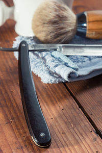 High angle view of shaving equipment on wooden table