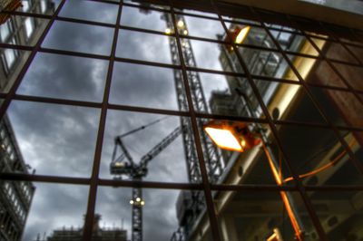 Low angle view of illuminated glass building against sky