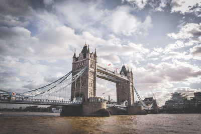 View of bridge over river against cloudy sky