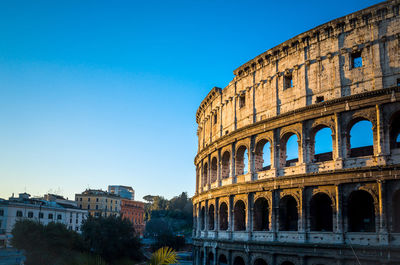 Low angle view of coliseum against clear sky