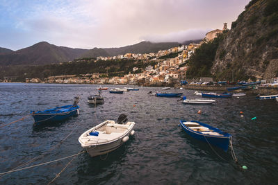 Sailboats moored on sea against sky