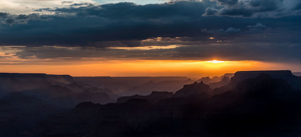 Scenic view of silhouette mountains against sky during sunset
