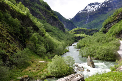 Scenic view of river flowing amidst green mountains