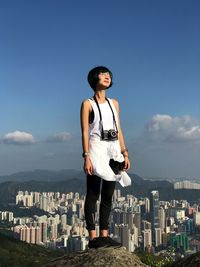 Young man standing in front of cityscape