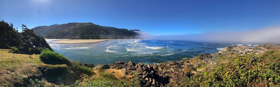 Panoramic view of sea against clear blue sky