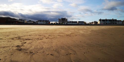 Beach by buildings against sky in city