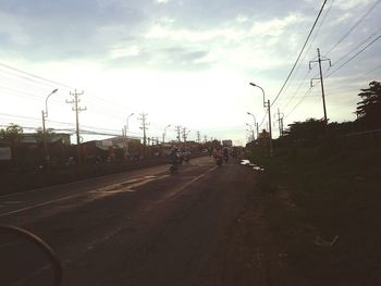 Cars on road against sky in city