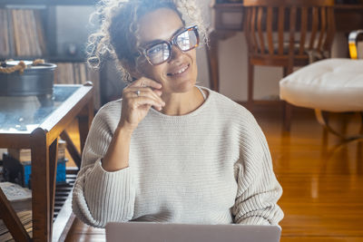 Portrait of young woman drinking coffee at home